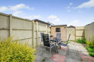 a patio with a table and chairs next to a fence at 2 Bed in Padstow oc-p00254 in Padstow