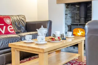 a living room with a coffee table and a fireplace at 3 Bed in Padstow oc-p00294 in Saint Issey