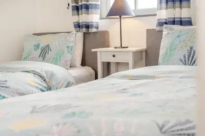 a bedroom with a bed and a table with a lamp at 3 Bed in Padstow oc-p00294 in Saint Issey