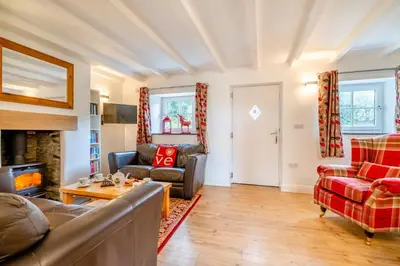a living room with a couch and chairs and a fireplace at 3 Bed in Padstow oc-p00294 in Saint Issey
