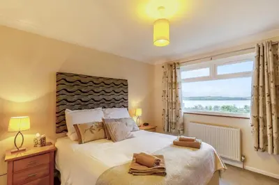 a bedroom with a large bed with a large window at 3 Bed in Padstow oc-p00226 in Padstow