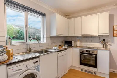 a white kitchen with a sink and a dishwasher at 3 Bed in Padstow oc-p00226 in Padstow