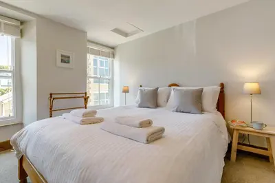 a bedroom with a large white bed with towels on it at 4 Bed in Padstow oc-p00297 in Padstow