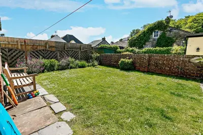 a yard with a bench and a brick fence at 4 Bed in Padstow oc-p00297 in Padstow