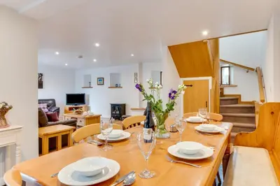 a dining room with a wooden table and chairs at 3 Bed in Padstow oc-p00281 in St Merryn