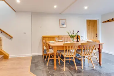 a dining room with a wooden table and chairs at 3 Bed in Padstow oc-p00281 in St Merryn