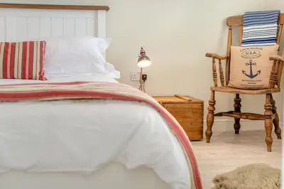 a bedroom with a bed and a rocking chair at 3 Bed in Padstow oc-p00329 in Padstow