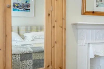 a reflection of a bedroom with a bed in a mirror at 3 Bed in Padstow oc-p00329 in Padstow
