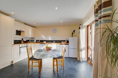 a kitchen with a table and chairs and a refrigerator at 1 Bed in Padstow oc-p00288 in St Merryn