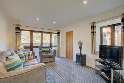 a living room with a couch and a television at 1 Bed in Padstow oc-p00288 in St Merryn