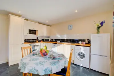 a kitchen with a table with a bowl of fruit on it at 1 Bed in Padstow oc-p00288 in St Merryn