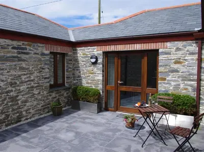 a patio with a wooden door and a table at 1 Bed in Padstow oc-p00288 in St Merryn