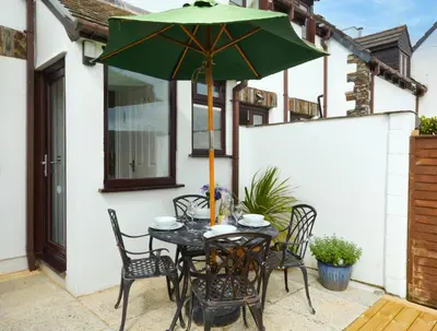 a table with a green umbrella on a patio at 2 Bed in Padstow oc-p00330 in Padstow