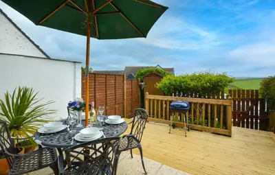 a patio with a table and an umbrella at 2 Bed in Padstow oc-p00330 in Padstow