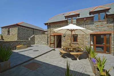 a patio with a table and an umbrella at 2 Bed in Padstow oc-p00282 in St Merryn