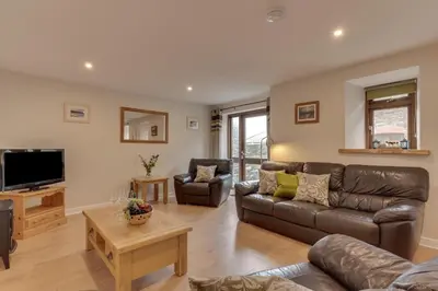 a living room with a couch and a tv at 2 Bed in Padstow oc-p00282 in St Merryn