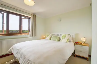 a bedroom with a large white bed and a window at 2 Bed in Newquay oc-p00335 in Mawgan Porth