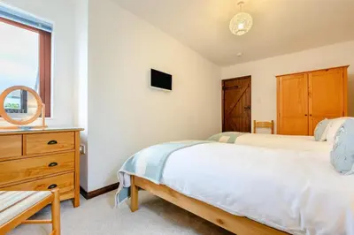 a bedroom with a bed and a dresser and a window at 2 Bed in Padstow oc-p00385 in Padstow