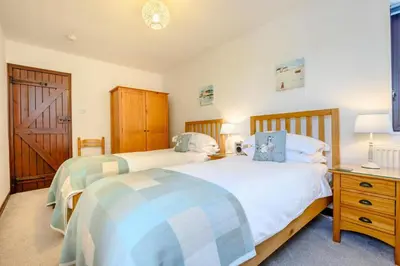 a bedroom with two beds and a wooden door at 2 Bed in Padstow oc-p00385 in Padstow