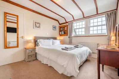 a bedroom with a large white bed and two windows at 2 Bed in Padstow oc-p00398 in St Merryn