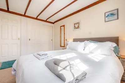 a bedroom with a white bed with towels on it at 2 Bed in Padstow oc-p00398 in St Merryn
