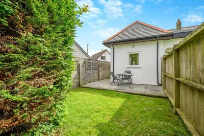 a garden with a fence and a table and chairs at 2 Bed in Padstow oc-p00398 in St Merryn