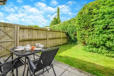 a table and chairs on a patio with a fence at 2 Bed in Padstow oc-p00398 in St Merryn