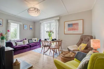 a living room with purple couches and a table at 2 Bed in Newquay oc-p00359 in Mawgan Porth
