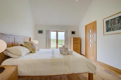 a large white bed with two stuffed animals on it at 3 Bed in Padstow oc-p00357 in St Merryn