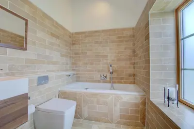 a bathroom with a bath tub and a toilet at 3 Bed in Padstow oc-p00357 in St Merryn