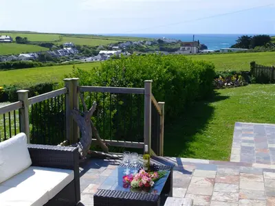 a patio with a bench and a table with flowers at 3 Bed in Padstow oc-p00357 in St Merryn
