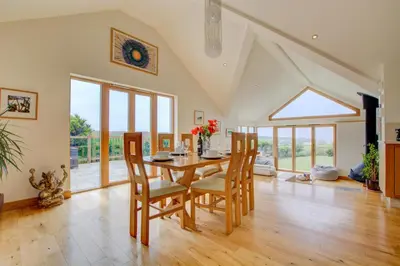 a dining room with a wooden table and chairs at 3 Bed in Padstow oc-p00357 in St Merryn