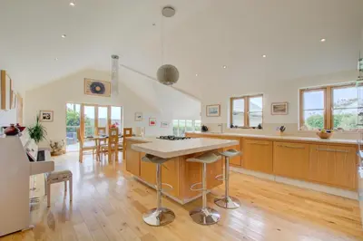 a large kitchen with a island in the middle at 3 Bed in Padstow oc-p00357 in St Merryn