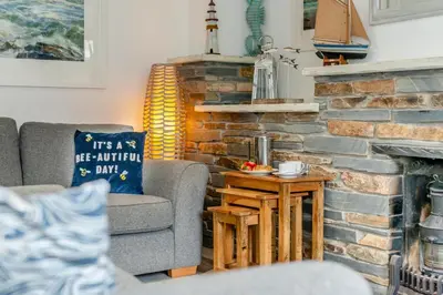 a living room with a couch and a brick fireplace at 3 Bed in Padstow oc-p00397 in Padstow