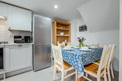 a kitchen with a table with chairs and a refrigerator at 3 Bed in Padstow oc-p00397 in Padstow