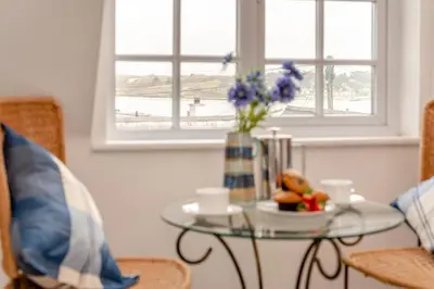 a glass table with a vase of flowers and cups at 3 Bed in Padstow oc-p00397 in Padstow