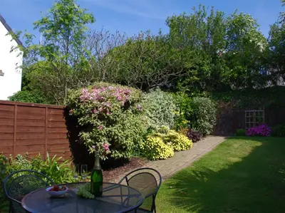 a garden with a table and chairs and flowers at 2 Bed in Padstow oc-p00390 in Padstow