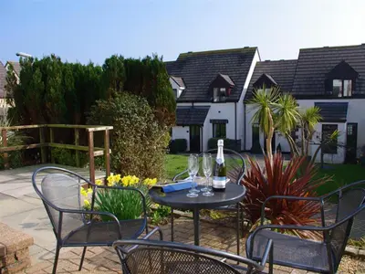 a patio with a table and chairs and a bottle of wine at 2 Bed in Padstow oc-p00390 in Padstow