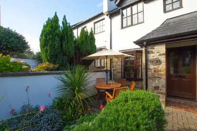 a patio with a table and an umbrella at 2 Bed in Padstow oc-p00424 in Padstow