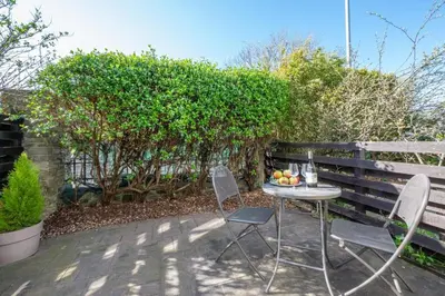 a table and chairs with a bowl of fruit on a patio at 2 Bed in Padstow oc-p00424 in Padstow