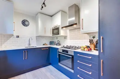 a blue kitchen with white cabinets and appliances at 2 Bed in Padstow oc-p00424 in Padstow