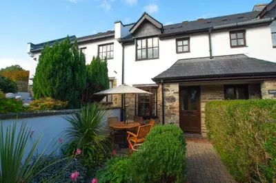 an external view of a house with a table and an umbrella at 2 Bed in Padstow oc-p00424 in Padstow