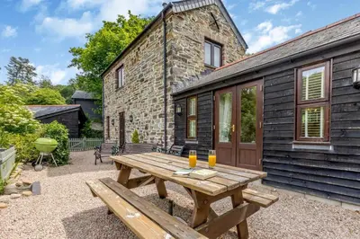 a wooden picnic table in front of a building at 2 Bed in Bodmin oc-p00405 in Bodmin