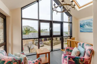 a living room with two chairs and large windows at 3 Bed in Wadebridge oc-p00421 in Saint Issey