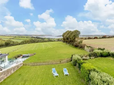 an aerial view of a lawn with two chairs at 3 Bed in Wadebridge oc-p00421 in Saint Issey