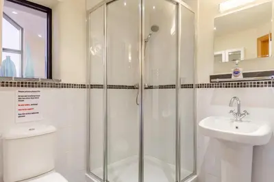 a bathroom with a shower and a toilet and a sink at 3 Bed in Wadebridge oc-p00421 in Saint Issey