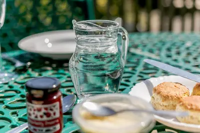 a table with a glass pitcher and a plate of food at 3 Bed in Wadebridge oc-p00427 in Little Petherick