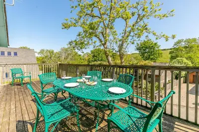 a patio with a table and chairs on a deck at 3 Bed in Wadebridge oc-p00427 in Little Petherick