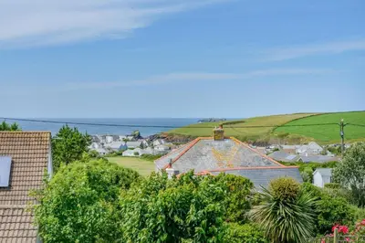 a small town with houses and the ocean in the background at 4 Bed in Padstow oc-p00401 in Padstow