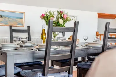 a dining room table with plates and flowers on it at 4 Bed in Padstow oc-p00401 in Padstow